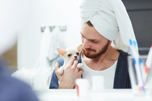 Man holds chihuahua after shower